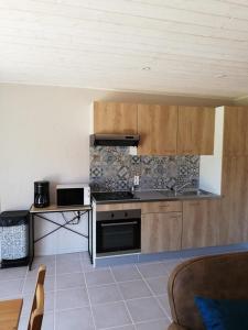 a kitchen with wooden cabinets and a stove top oven at La Maison de Toi et Moi in Castellane