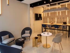 een wachtkamer met stoelen en tafels en een aanrecht bij ibis Styles Paris Opera Lafayette in Parijs