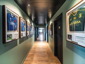 un couloir d'un musée avec des photos sur les murs dans l'établissement ibis Styles Castelnaudary, à Castelnaudary