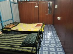 蒂鲁奇奇拉帕利Terrace Camp的有两张床、一张桌子和一张椅子的房间