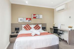 a bedroom with a large bed and a desk at Best Western Plus Camperdown Suites in Sydney