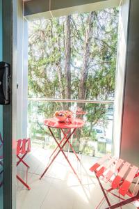 Best Western Plus Camperdown Suites في سيدني: طاولة حمراء مع وعاء من الفواكه على شرفة