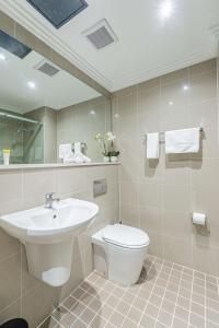 bagno con lavandino, servizi igienici e specchio di Best Western Plus Camperdown Suites a Sydney