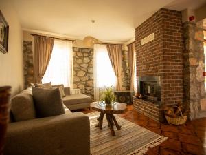 sala de estar con sofá y chimenea de ladrillo en Karakaya Villa Suite Hotel, en Sakarya