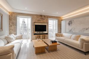 a living room with a couch and a tv at housingcoruña REAL58 in A Coruña
