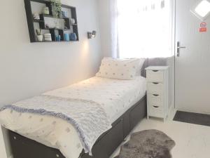 a small bedroom with a bed and a dresser at Modern Studio apartment in Newcastle upon Tyne in Newcastle upon Tyne