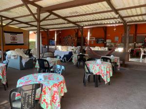 a restaurant with tables and chairs with flowers on them at Pousada e Restaurante Tio Paulo in Teresópolis