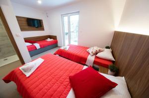 2 posti letto in una camera con rosso e bianco di Gostilna Pugelj a Novo Mesto