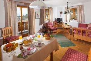 a living room with a table with food on it at Ferienwohnungen Zweckl in Marktschellenberg