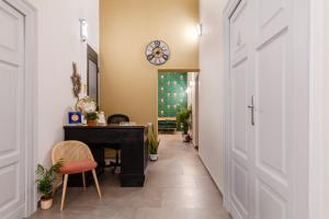 拿坡里的住宿－Monteoliveto 33，走廊上设有一张桌子和墙上的时钟