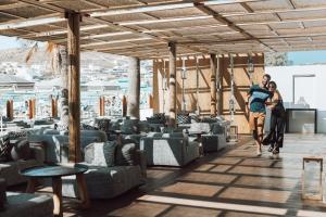 two people walking through a room with couches at Mykonos Blanc - Preferred Hotels & Resorts in Ornos