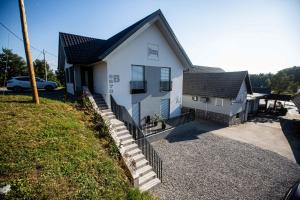 una casa bianca con un tetto nero e una recinzione di Gostilna Pugelj a Novo Mesto