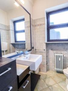 ein Badezimmer mit einem Waschbecken, einem WC und einem Spiegel in der Unterkunft MYHOUSE INN LINGOTTO - Affitti Brevi Italia in Turin