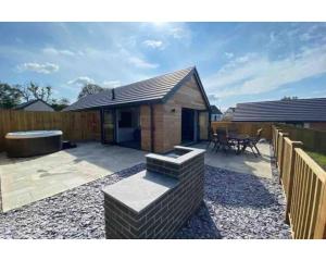 Willow Cottage في تينبي: حديقة خلفية بها شواية وسياج خشبي +31 صورة