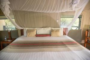 ein Schlafzimmer mit einem Himmelbett in der Unterkunft Twiga Safari Lodge in Murchison Falls National Park