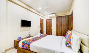 a bedroom with a white bed and a television at FabHotel Carnival in Kolkata