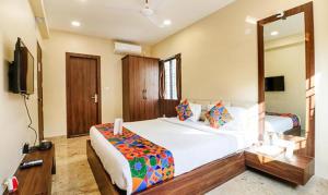a bedroom with a large bed and a mirror at FabHotel Carnival in Kolkata