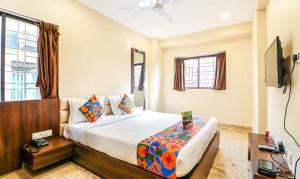 ein Schlafzimmer mit einem großen Bett und einem TV in der Unterkunft FabHotel Carnival in Kalkutta