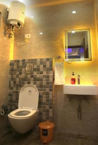 bagno con servizi igienici, lavandino e specchio di CASA CENTRAL a Nuova Delhi