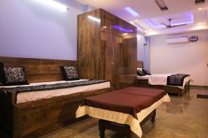 新德里的住宿－CASA CENTRAL，一间设有两张床的房间,内设一张长凳
