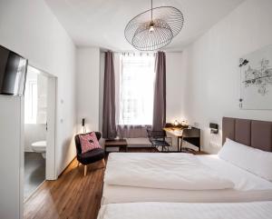 Schlafzimmer mit einem Bett, einem Schreibtisch und einem Stuhl in der Unterkunft acor Boutique Hotel in Heidelberg