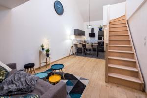 uma sala de estar com um sofá e uma escada em Duplex de 80m2 dans un village de caractère ! em Saint-Marceau