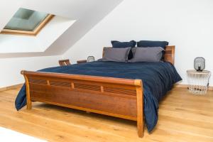 um quarto com uma cama grande e um cobertor azul em Duplex de 80m2 dans un village de caractère ! em Saint-Marceau