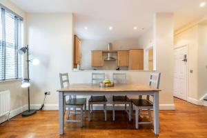 cocina y comedor con mesa y sillas en Luxury 2BDR duplex apt, N London, 2 floors, en Enfield