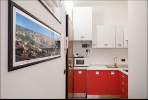 kuchnia z czerwonymi szafkami i zdjęciem na ścianie w obiekcie Dreaming Suite w Weronie