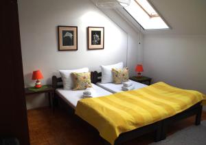 una camera con 2 letti con lenzuola e lampade gialle di Danica Apartment a Belgrado