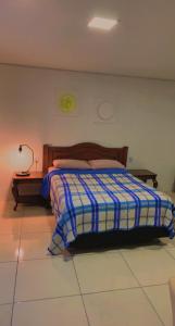 ein Schlafzimmer mit einem Bett und einer Lampe auf einem Fliesenboden in der Unterkunft Flat Deluxe2 Gramado in Gramado