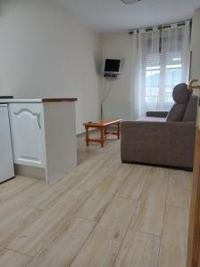 uma sala de estar com um sofá e um piso de madeira em Hotel Los Robles em Cangas de Onís