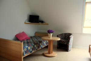 a bedroom with a bed and a table and a chair at Landblick in Nahrendorf