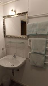 a bathroom with a sink and a mirror and towels at Landblick in Nahrendorf