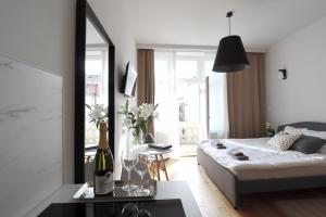 een woonkamer met een bed en een fles wijn bij Apartamenty na Teatralnej 14 - Katowice in Katowice