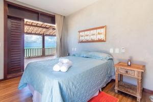 ein Schlafzimmer mit einem Bett mit zwei Handtüchern darauf in der Unterkunft Casa de Luxo na Beira Mar de Porto Mirim/RN in Jacumã