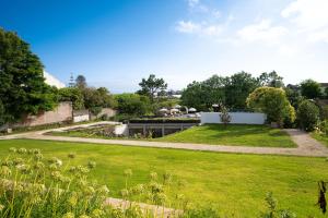 a garden with green grass and a building at Senhora da Rosa, Tradition & Nature Hotel in Ponta Delgada