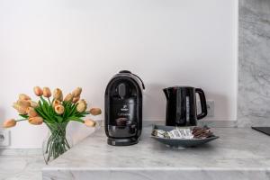a coffee maker on a counter next to a vase of flowers at Apartamenty Jantaris II by Renters in Mielno