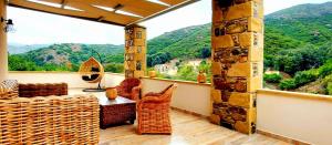 Villa 4 DESTINA في Élos: شرفة مع طاولة وكراسي وإطلالة على الجبال