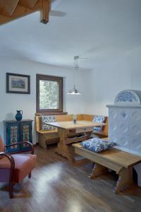 a living room with a wooden table and benches at Casa Sauris in Sauris