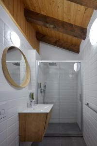 uma casa de banho com um lavatório e um chuveiro com um espelho. em Casa Sauris em Sauris