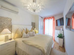 a bedroom with a large bed and a chandelier at Apartment Viva la Vita in Cavtat
