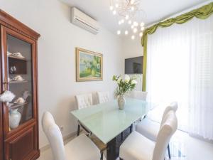 a dining room with a glass table and white chairs at Apartment Viva la Vita in Cavtat