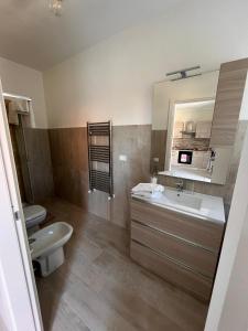 a bathroom with a sink and a toilet and a mirror at Casa Cost 2 in Vetralla