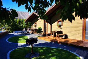 un patio con mesa y bancos junto a un edificio en Resort Baure, en Palanga