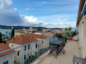 uma varanda com cadeiras e vista para a cidade em Superbe Appartement avec terrasse vue mer em Le Lavandou