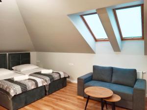 a bedroom with a bed and a couch and a table at Apartamenty Radom Klwatecka 20 in Radom