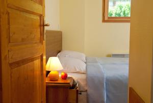 a bedroom with a bed and a table with a lamp at Olydea Fontaine du Roi in Saint-Jean-dʼArves