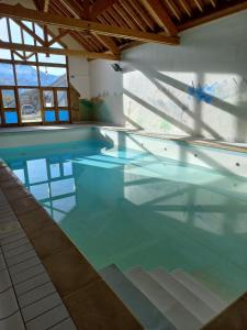 a large swimming pool with blue water at Olydea Fontaine du Roi in Saint-Jean-dʼArves