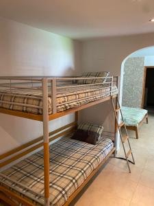 two bunk beds in a room with a chair at Villa Francisco in Calonge